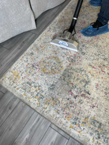 A professional cleaning an area rug with specialized equipment at Two Sheas Restoration in Tulsa, OK.
