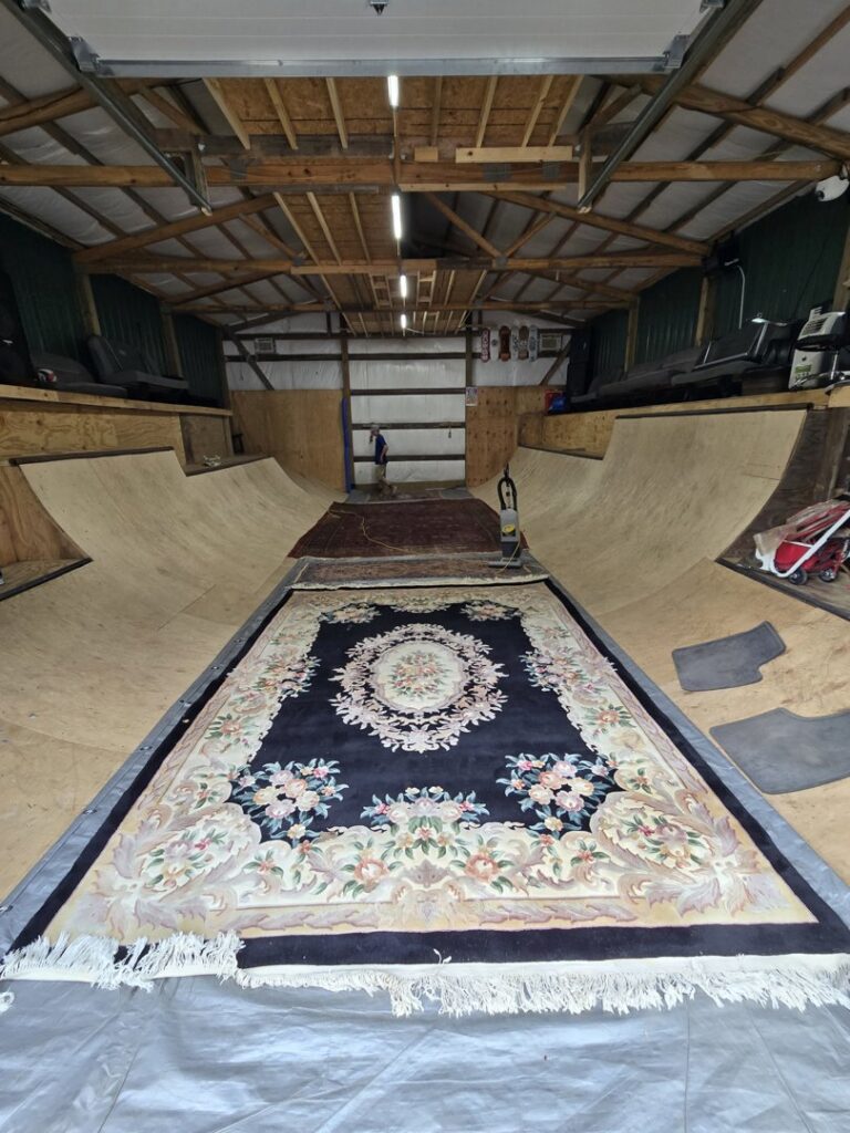 Multiple large area rugs laid out on a protective tarp for cleaning by Inspection Ready LLC in Bellevue, NE.