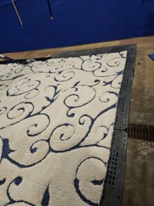 A patterned area rug drying on a rack after professional cleaning by BEST Professionals Cleaning, LLC in Lancaster, PA