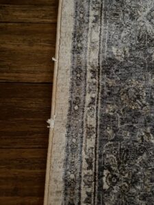 A close-up detail of the edge of an area rug, showing its texture and potential need for cleaning or repair by Hydro Clean in Baltimore, MD.