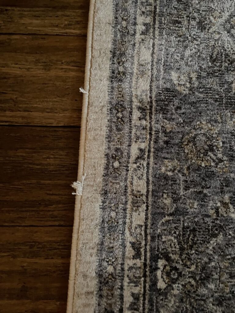 A close-up detail of the edge of an area rug, showing its texture and potential need for cleaning or repair by Hydro Clean in Baltimore, MD.