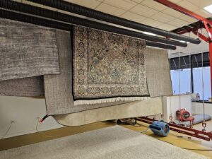 Several freshly cleaned area rugs hanging to dry in a professional facility at Personal Touch Carpet Cleaning in Chicago, IL.