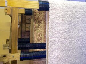 Various area rugs hanging on a drying rack after professional cleaning by Celtic Carpet Cleaner in Fort Lauderdale, FL.