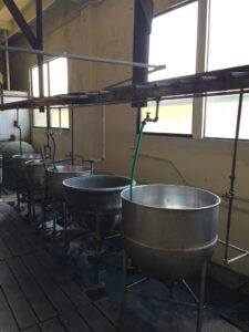 Various area rugs neatly stored on shelves in the processing and storage facility at Deluxe Dye Works in San Jose, CA.