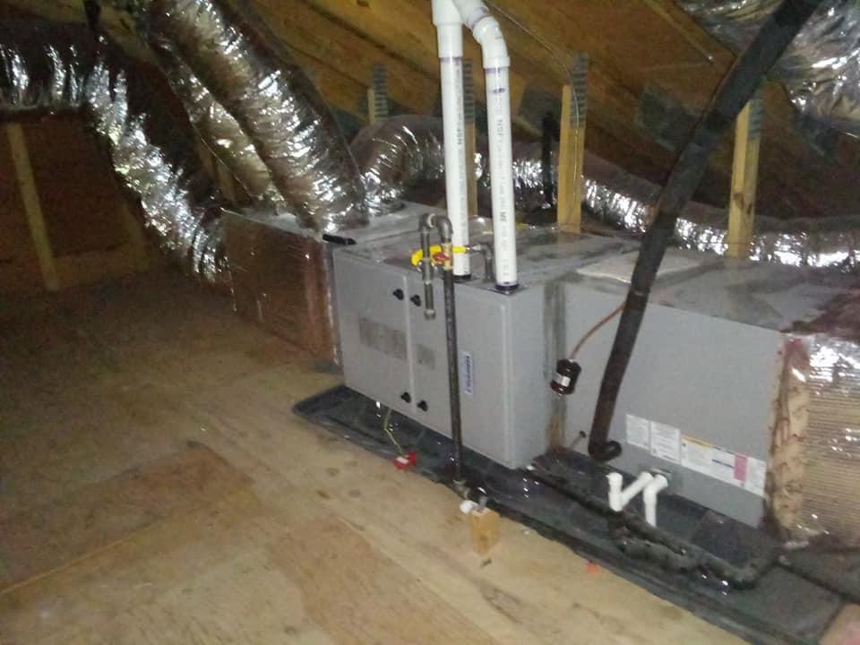 An air handler unit and insulated ductwork installed in an attic by Air We Are in Toms River, NJ.