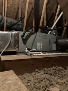 An air handler or furnace unit with ductwork installed in an attic space by Tack Mechanical LLC in Baltimore, MD.