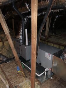 An indoor air handler unit with connected ductwork installed in an attic by Trinity Climate Control in Goldsby, OK.
