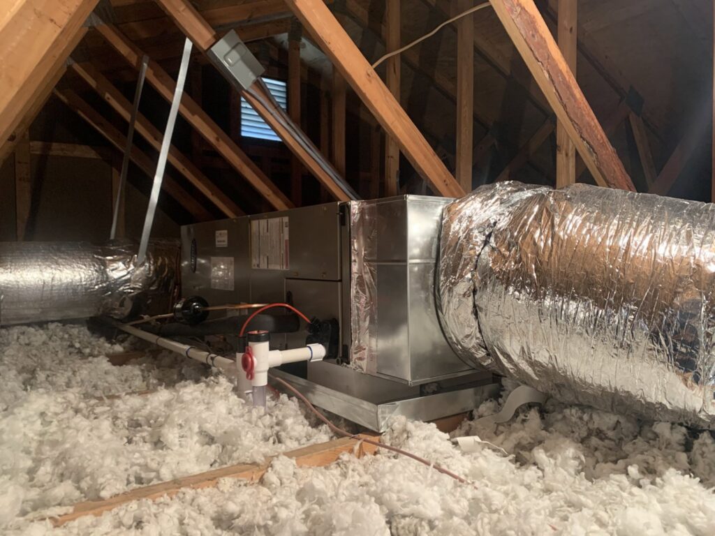 An air handler unit with ductwork installed in an attic with insulation by Air Energy Solutions in North Chesterfield, VA