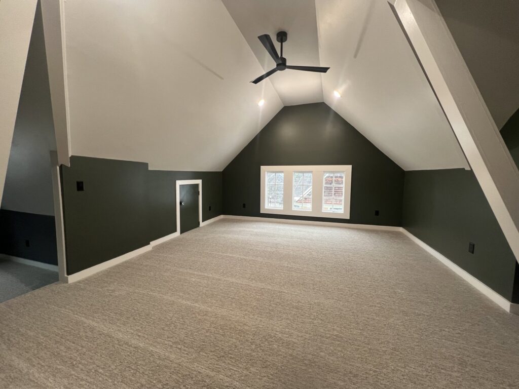 A spacious attic bonus room with new grey carpet installed by Absolute Floor Covering, Inc in Kentwood, MI.