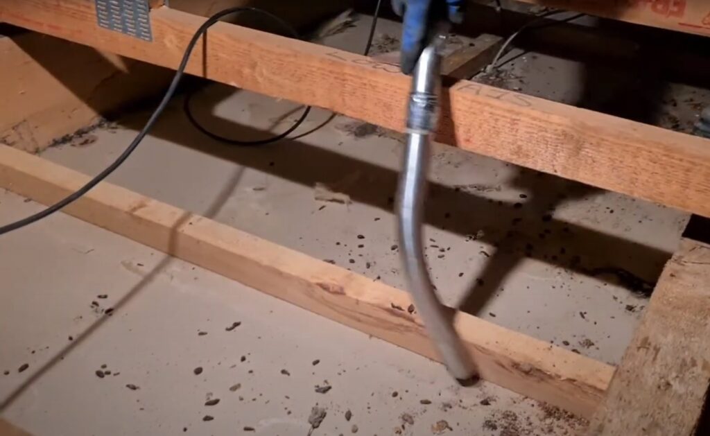 A vacuum hose cleaning pest debris and droppings from an attic space by Rodent Control Cleveland in Cleveland, OH.