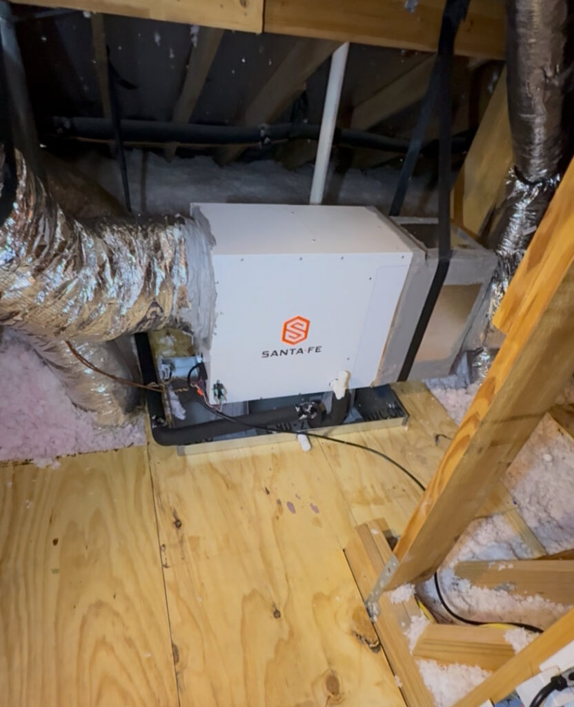 A Santa Fe whole-home dehumidifier unit installed in an attic, connected to HVAC ductwork by Gibson's Air Conditioning & Heating in Corpus Christi, TX.