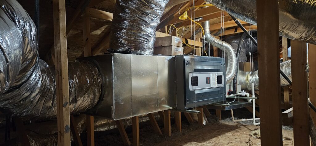 An HVAC air handler unit and flexible ductwork installed in an attic space by HoxAir Heating & Cooling in Phoenix, AZ