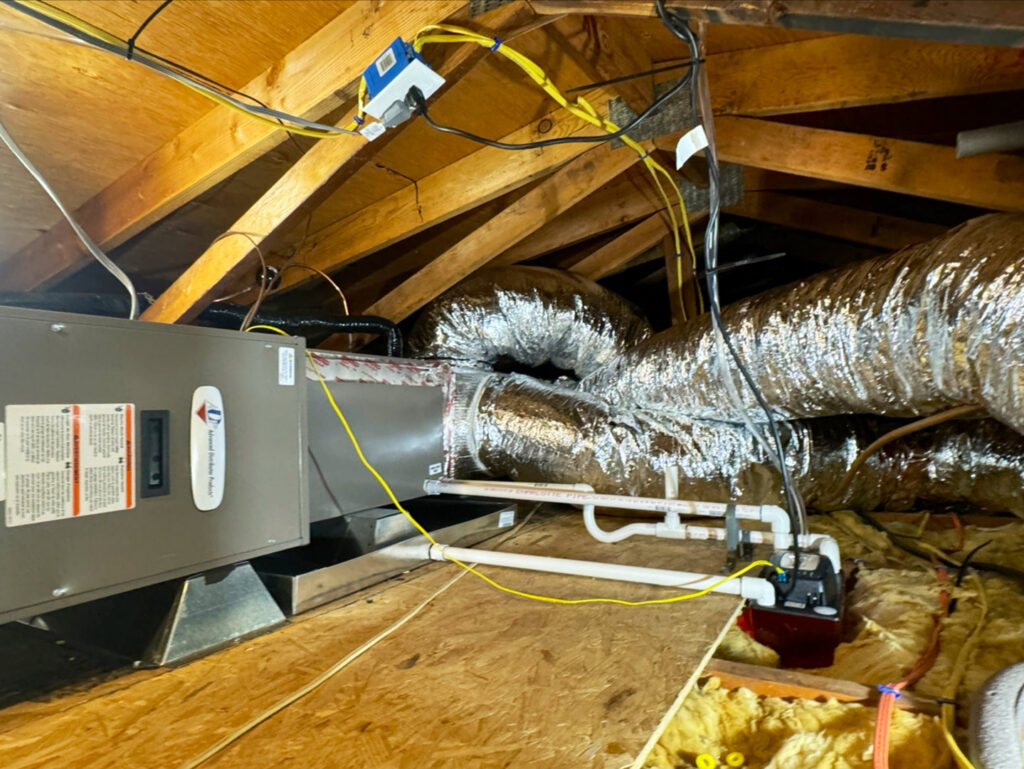An HVAC air handler unit and insulated ductwork installed in an attic space by Pelican Heating and Air in Carlsbad, CA.