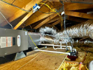 An HVAC air handler unit and insulated ductwork installed in an attic space by Pelican Heating and Air in Carlsbad, CA.
