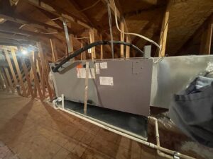 An indoor HVAC air handler unit installed in an attic with ductwork by Klee's Climate Control in Mesa, AZ.