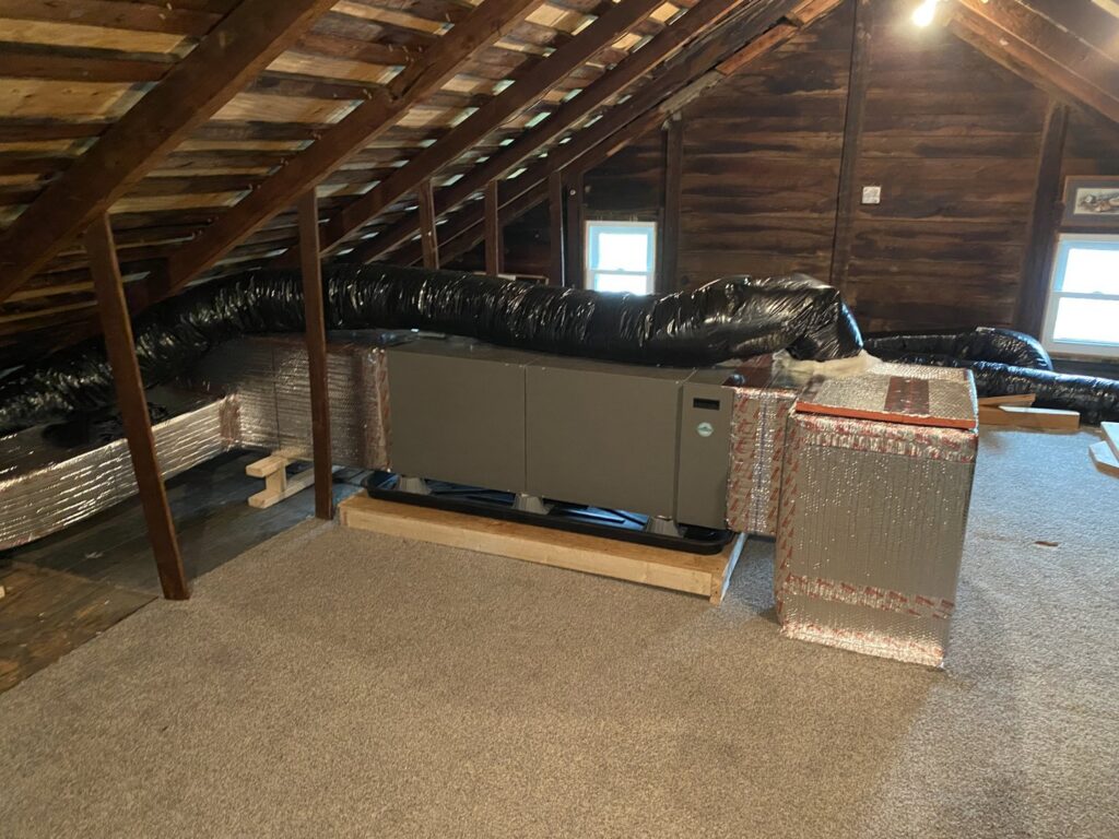 An HVAC air handler unit and ductwork installed in an attic by Strine's Heating & A/C in York, PA.