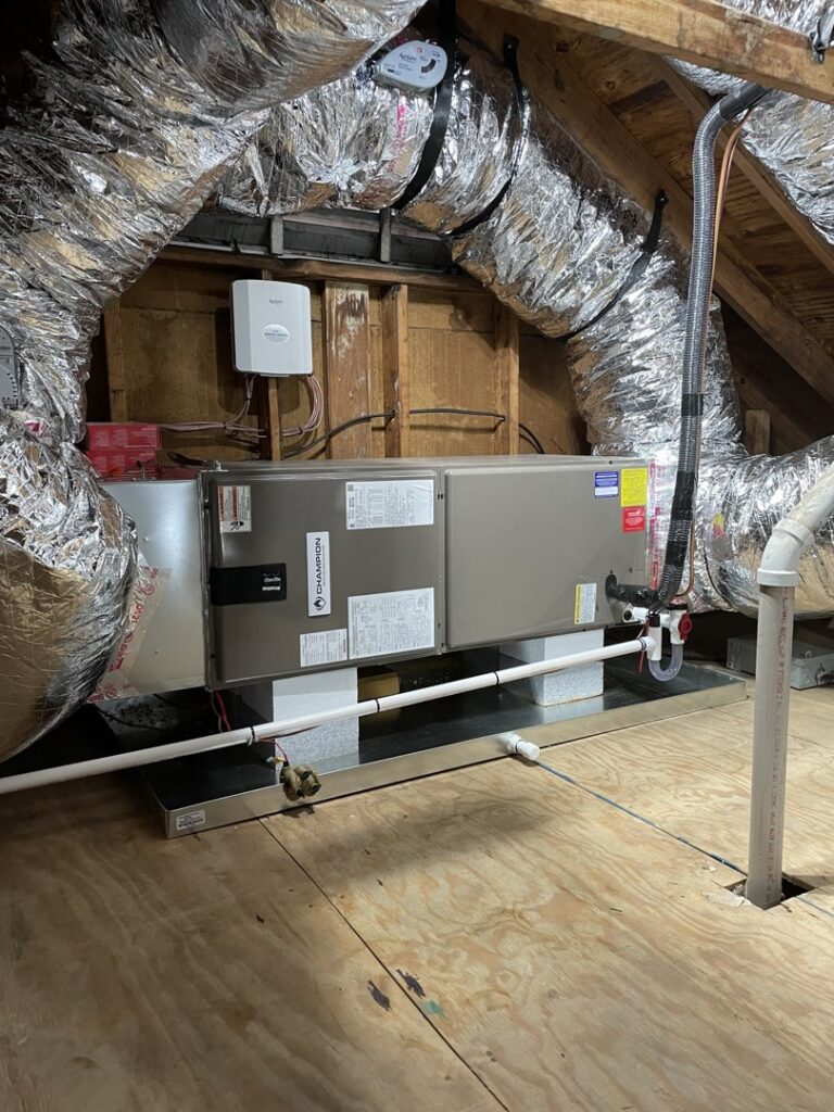 An indoor HVAC air handler unit with ductwork installed in an attic by Coastal Breeze Heating-Cooling-Plumbing in Hampton, VA.