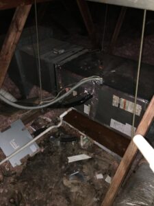 An HVAC air handler unit located in an attic, surrounded by insulation and ductwork, installed by The A/C Guy in Shreveport, LA.
