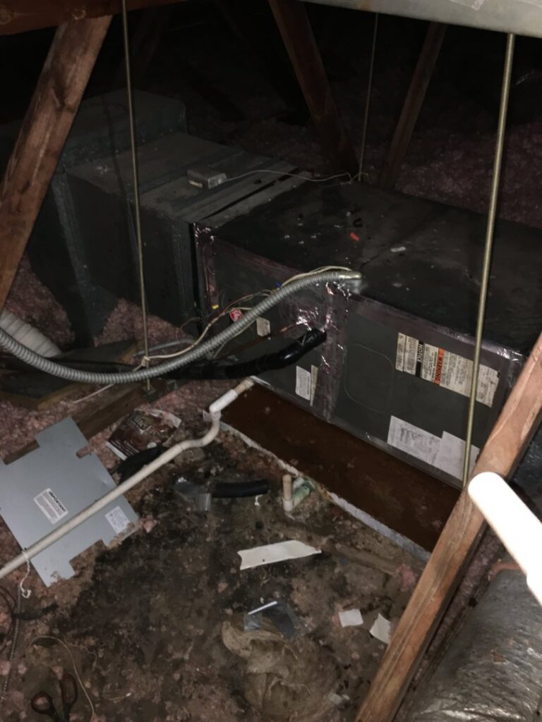 An HVAC air handler unit located in an attic, surrounded by insulation and ductwork, installed by The A/C Guy in Shreveport, LA.