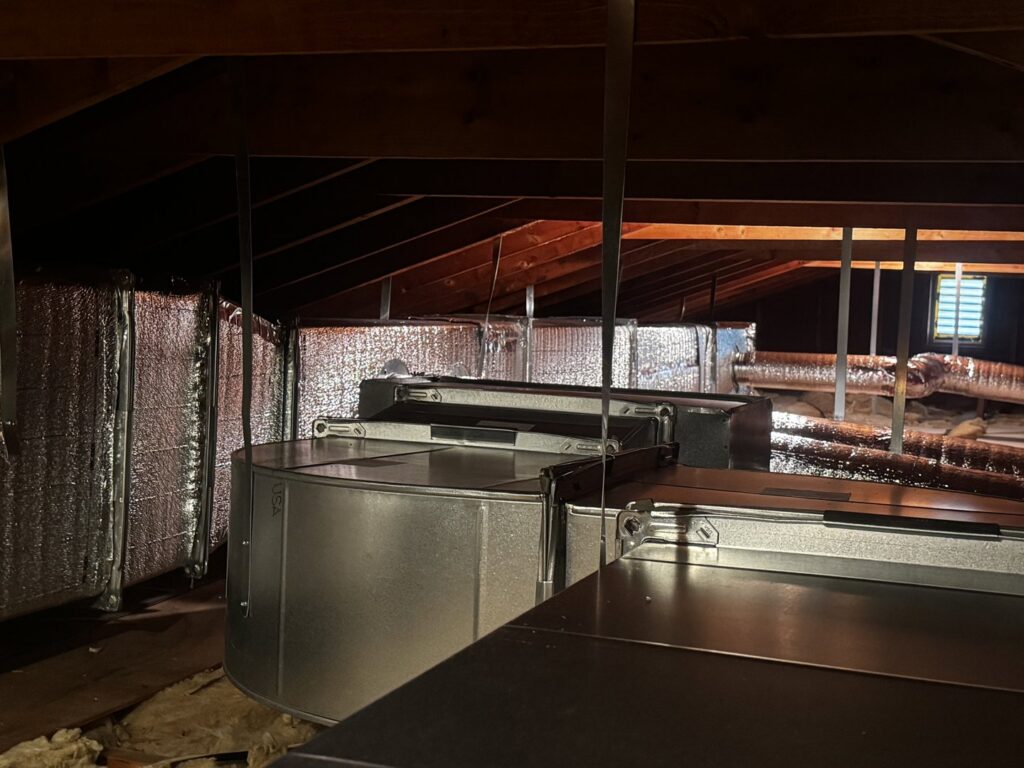 New HVAC ductwork and an air handler unit installed in an attic by PureTemp Heating and Cooling in Salem, NH.