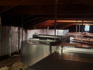 New HVAC ductwork and an air handler unit installed in an attic by PureTemp Heating and Cooling in Salem, NH.