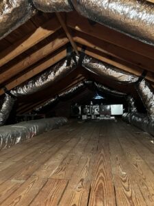 An attic space showing a newly installed HVAC unit and ductwork by Hendrix Heating & Air in Newport News, VA.