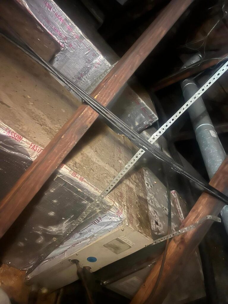 An HVAC unit and insulated ductwork visible in a dark attic space, installed by Circle L Heating and Cooling LLC in Atmore, AL.