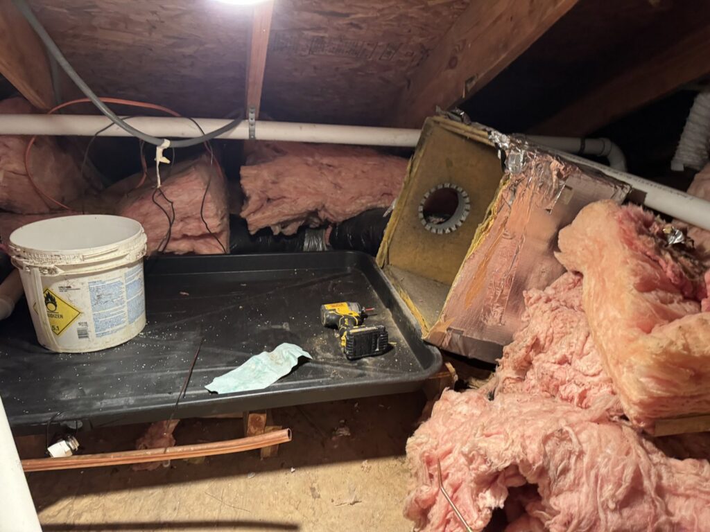 An old or damaged HVAC air handler unit in an attic, awaiting repair or replacement by Southern Climate Pros in Jasper, AL.