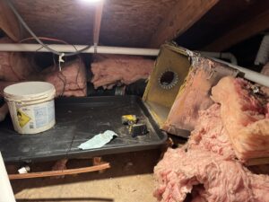 An old or damaged HVAC air handler unit in an attic, awaiting repair or replacement by Southern Climate Pros in Jasper, AL.