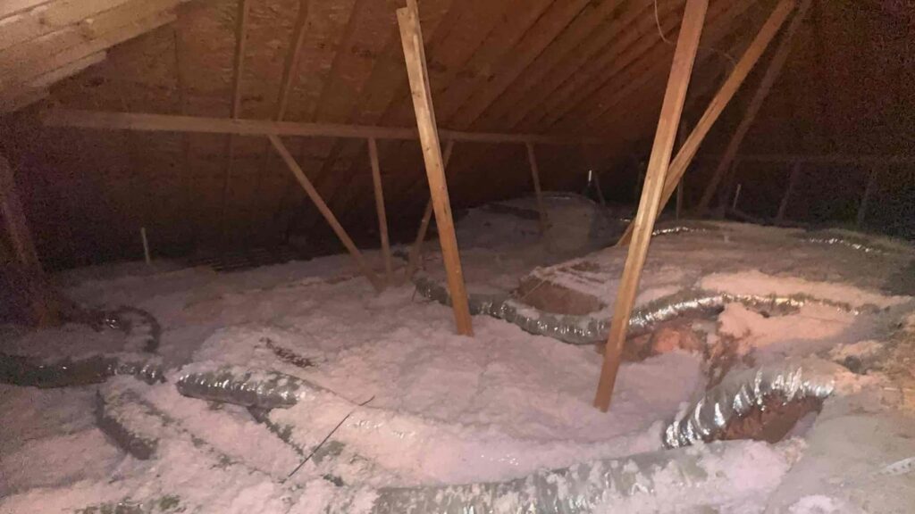 Attic space showing insulation and flexible ductwork installed by Integrity Services Heating and Cooling in Madison, AL.