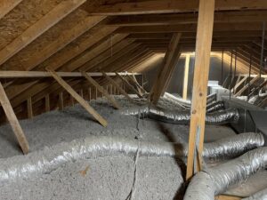 Fresh attic insulation being installed in a residential home by Nikron Pest & Termite Control in Lafayette, LA.