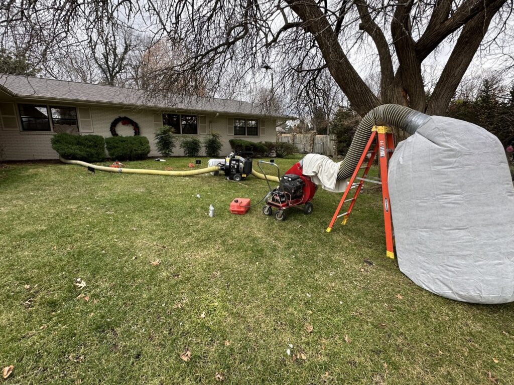Attic insulation restoration equipment and Critter Control truck on a residential lawn in Springfield, MO