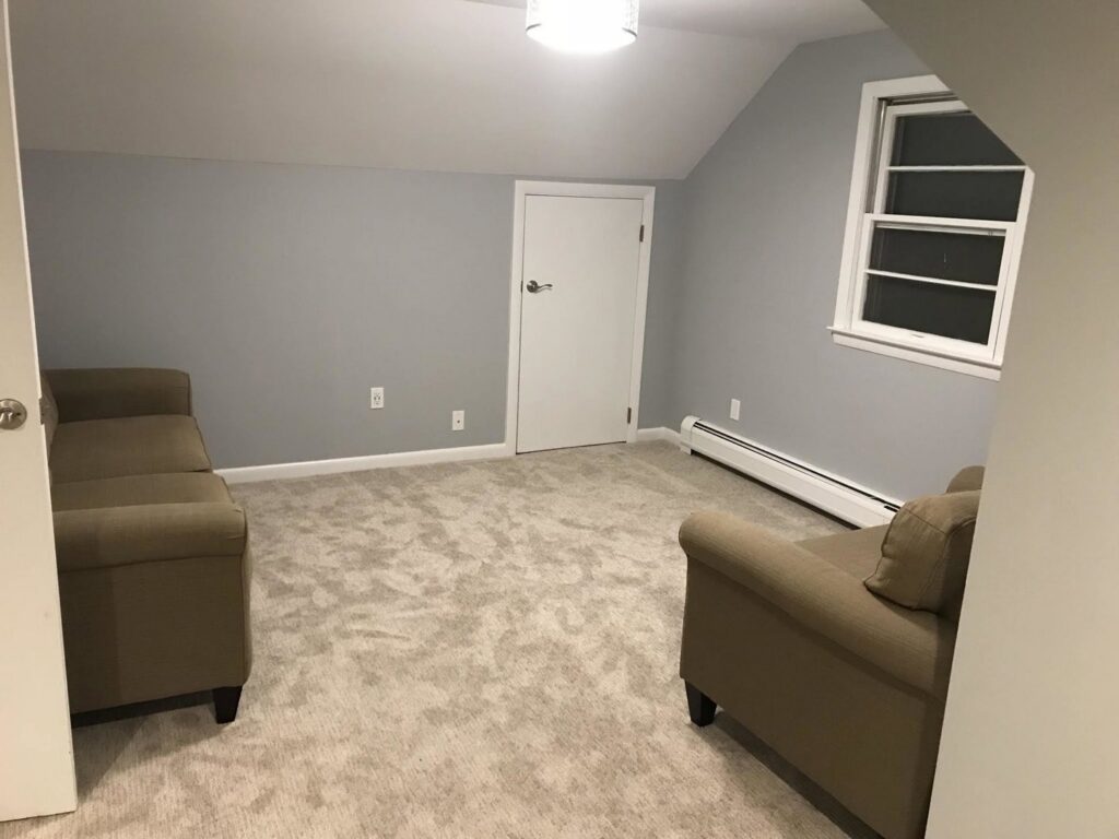 A newly carpeted attic room with light gray carpet installed by Carpet King and Flooring in Myrtle Beach, SC.