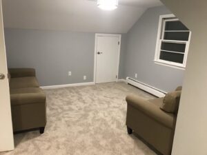 A newly carpeted attic room with light gray carpet installed by Carpet King and Flooring in Myrtle Beach, SC.