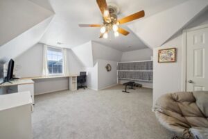 A spacious attic room featuring a new gray carpet installation, showcasing the work of B A Carpet and Flooring in Broken Arrow, OK.