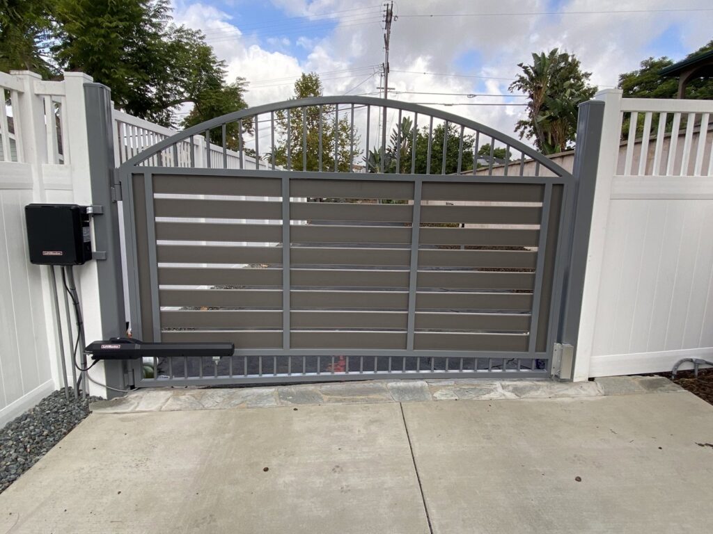 An automated gate installation with a white vinyl fence by Gates Access Solutions in San Diego, CA