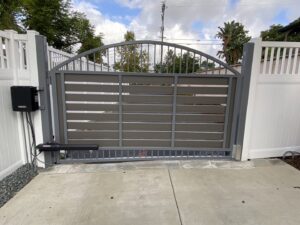 An automated gate installation with a white vinyl fence by Gates Access Solutions in San Diego, CA
