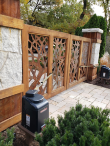 Close-up of an automated wooden gate with a unique tree design and opener by Gate Options in West Chicago, IL