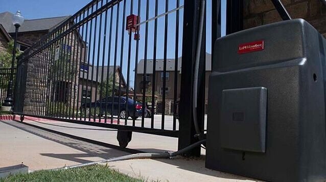 An automatic gate opener installed on a black metal security gate by Overhead Door Company of Maricopa & Pinal County in Mesa, AZ.