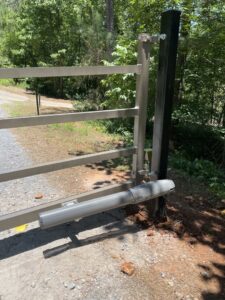 An automatic gate opener mechanism attached to a metal gate post, installed by Gates Contractors in White, GA.