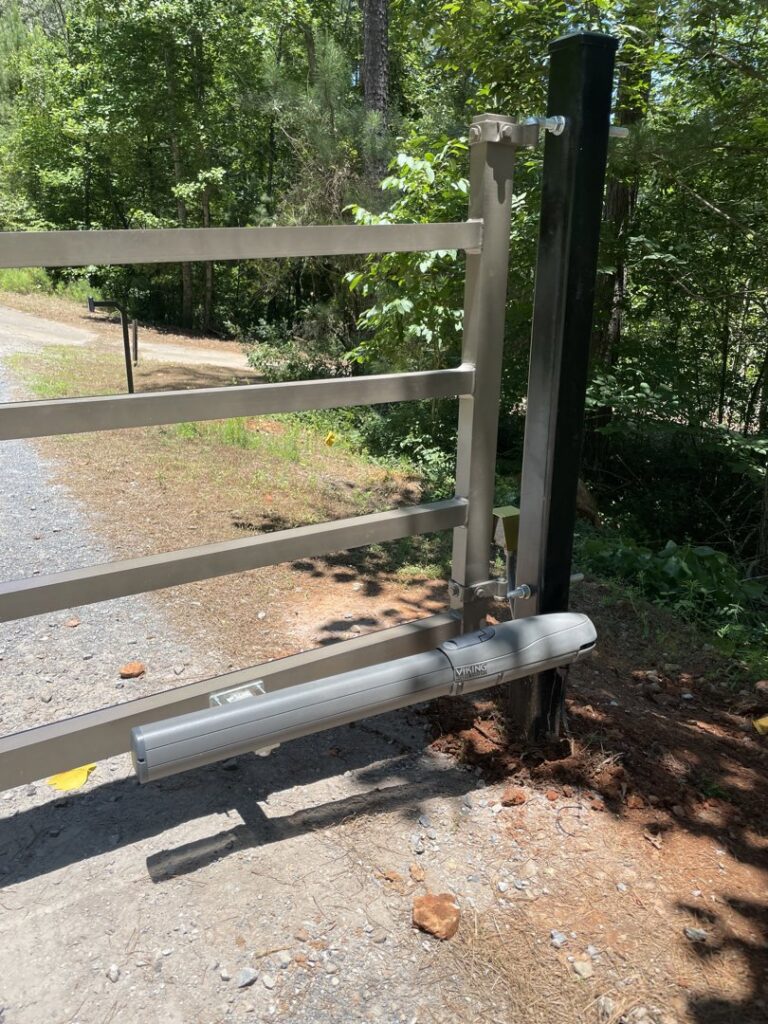 An automatic gate opener mechanism attached to a metal gate post, installed by Gates Contractors in White, GA.