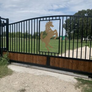 An automatic metal and wood gate featuring a horse cutout design by Craftsman Automatic Gates in Dallas, TX