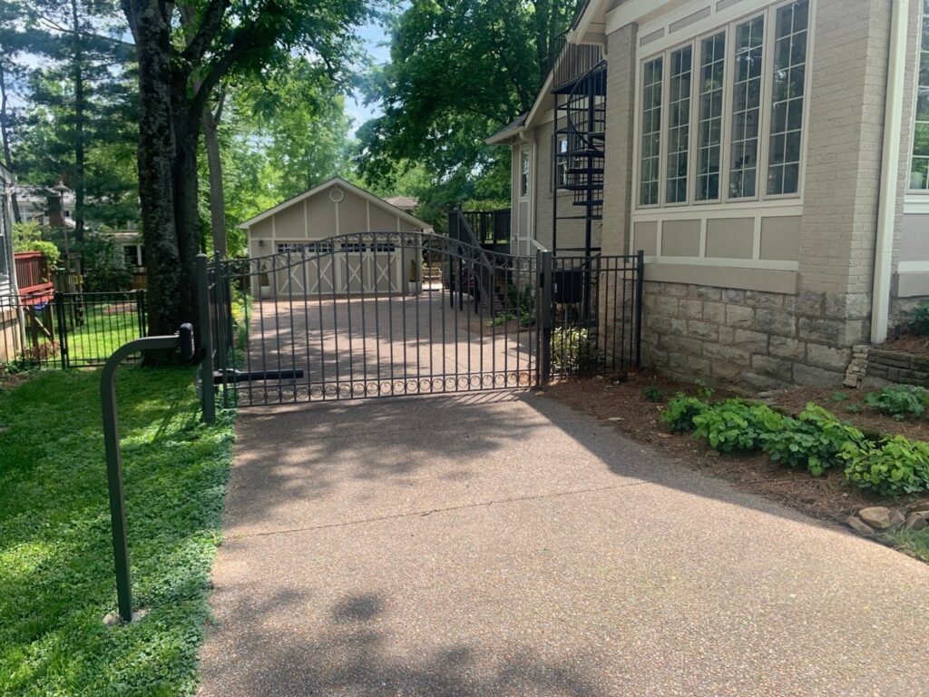 An automatic black ornamental metal driveway gate installed by America's Fencing in Nashville, TN.