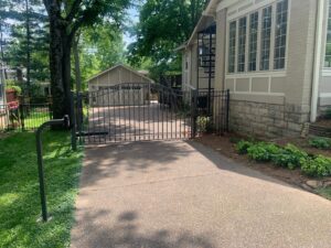 An automatic black ornamental metal driveway gate installed by America's Fencing in Nashville, TN.