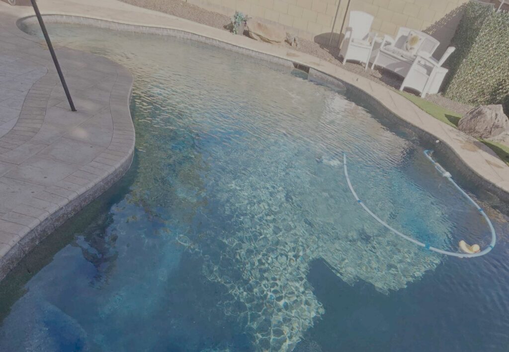 An automatic pool cleaner hose visible in a clean swimming pool, demonstrating service by Pool Pals in Franklin, MA.