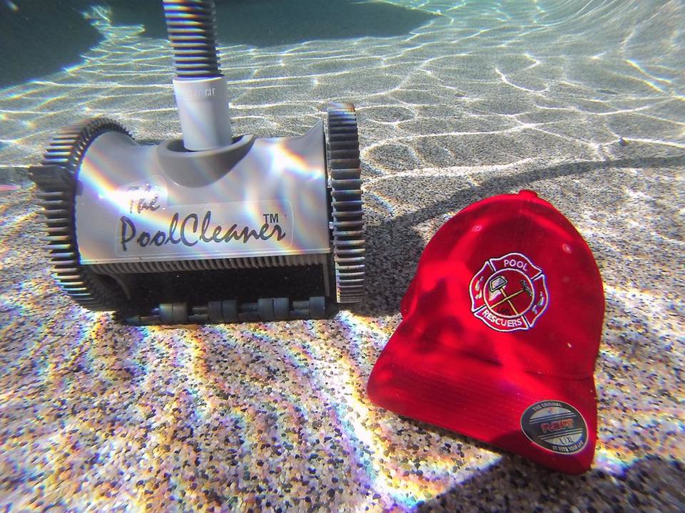 An automatic pool cleaner and a Pool Rescuers LLC hat visible underwater, demonstrating cleaning services in Gilbert, AZ.