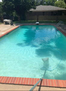 An automatic pool cleaner vacuuming the bottom of a swimming pool by Four Seasons Pool Services in Shreveport, LA.