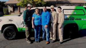 The AZ Shield Pest Control team stands proudly with their branded service truck in Gilbert, AZ, ready for pest and wildlife control jobs.