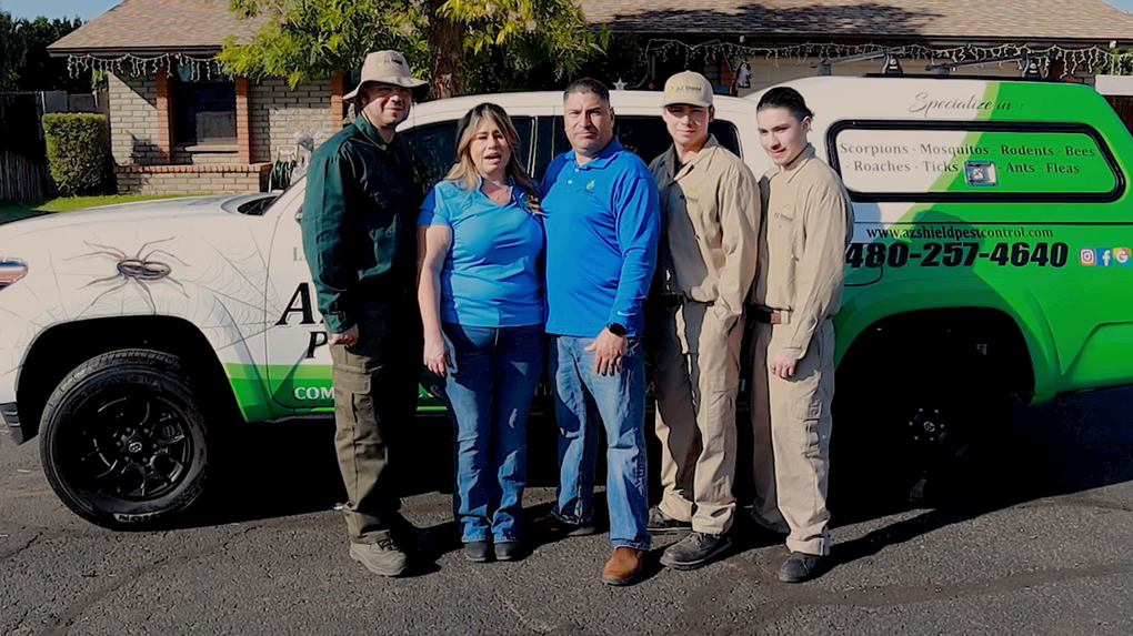 The AZ Shield Pest Control team stands proudly with their branded service truck in Gilbert, AZ, ready for pest and wildlife control jobs.
