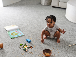 A baby playing on soft gray textured carpet installed by 180 Degree Floors in Nashville, TN.